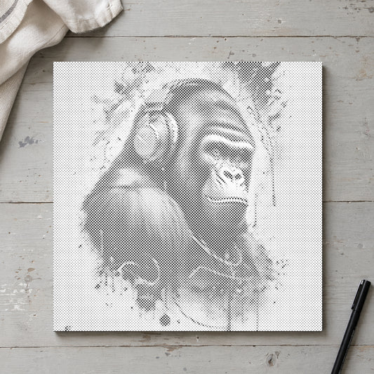 Prickmålningen “Gorilla med hörlurar”, sedd ovanifrån på ett arbetsbord i mjukt dagsljus.